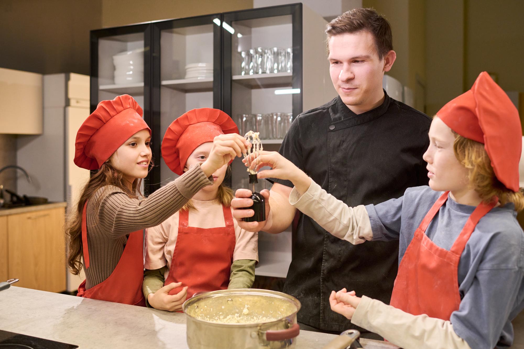 Chef demonstrating sauce technique to students